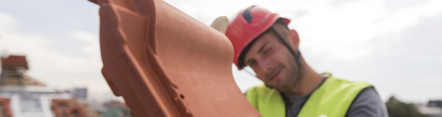 Urban roofers showing product installation roof tiles construction worker wearing hard hat
